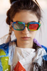 Obraz premium Woman wearing plastic on white background. Female model in clothes and shoes made of garbage. Fashion, style, recycling, eco and environmental concept. Too much pollution, we're eating and taking it.