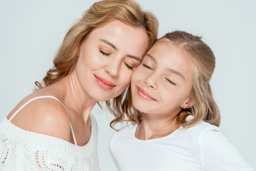 smiling mother and daughter with closed eyes isolated on grey