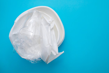 Fototapeta premium plastic dish and plastic cup on blue paper background