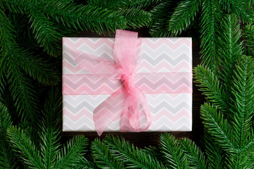 Top view of Christmas gift box on fir tree background. Time for holiday concept with copy space