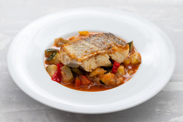 cod fish with vegetables in white plate