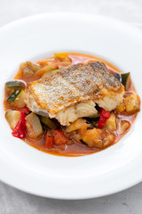 cod fish with vegetables in white plate