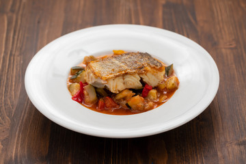 cod fish with vegetables in white plate