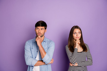 Photo of two people couple looking distrustful empty space have doubts think over creative plan wear stylish casual outfit isolated pastel purple color background