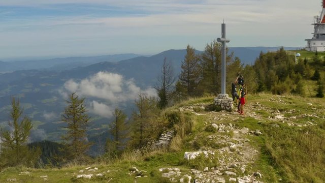 Close up aerial around joyful and cheerful hikers who reached the highest peak on the Ur&scaron;lja gora mountain in slovenia