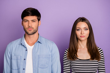 Photo of two funny people couple not smiling looking seriously on camera not talk to each other wear stylish casual outfit isolated pastel purple color background