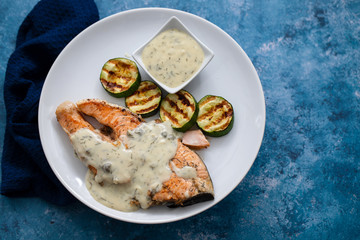 salmon with sauce and grilled vegetables on white plate