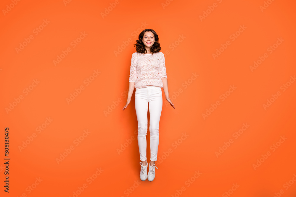 Poster Full length photo of positive cheerful girl have spring time holidays jump enjoy content emotions wear casual style outfit sneakers isolated over orange color background