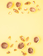 Wallnut seeds on yellow table, top view and copy space