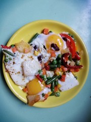 eggs benedict with vegetables on a yellow plate