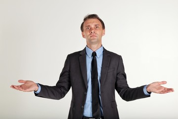 I don't know,portrait of a businessman wearing a black suit opened his hands and spread his arms out on white background,close up shot 