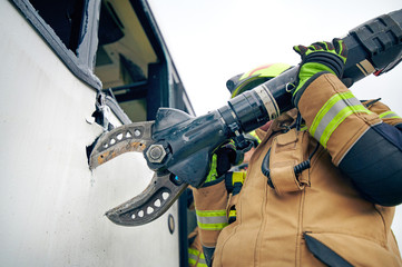 Fireman cuts the sheet metal with pliers, at car accident scene