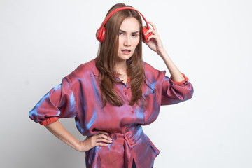Too loud.  portrait of  young asian woman  holding  headphones and making unhappy face.