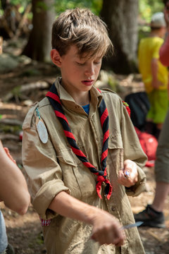 boy scout with a pocket knife in the forest