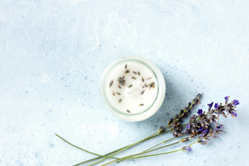 A lavender-scented candle with lavender flowers and a place for text. Zero-waste Christmas concept, a handmade New Year gift in a recycled glass jar, overhead shot