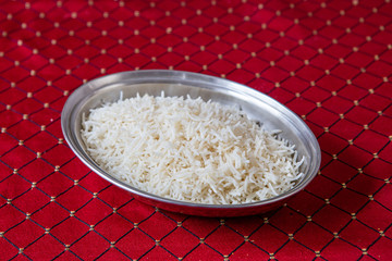 Indian Asian boiled rice on a red tablecloth.