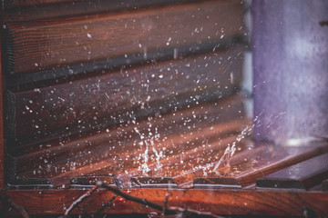 Close-up of drops falling on a wooden background in an urban graduation tower