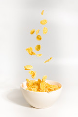 Corn flakes falling to the white bowl. Motion.
