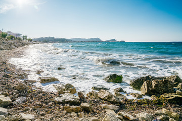 Shoreline of Adriatic sea wth clear blue water and pebble beach, Corfu 2018