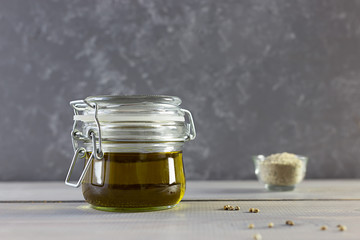 Hemp oil in a glass bottle, seeds and flour on a gray wooden background. Horizontal photo.