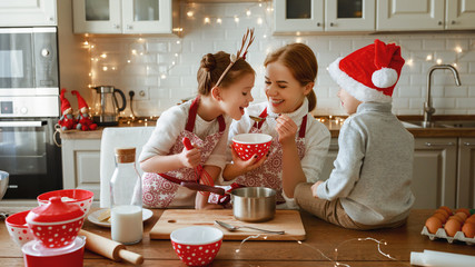 happy family mother and children bake christmas cookies