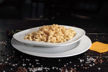 Pasta with sauce in white plate, on black board