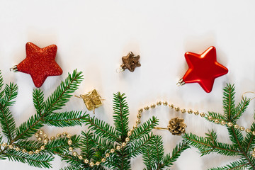 Modern Christmas composition. Christmas toys, brown and red decorations, spruce branches, festive lights on a white background. Flat lay, top view. Holiday card