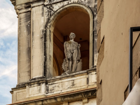 Sculpture of a naked man in the belvedere of La Caixa building in Tarrega (Catalonia, Spain). One great classical statue of standing person presiding over the Plaza Mayor on the roof of the building