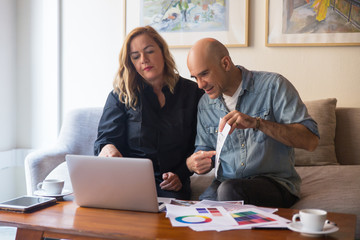 Customers consulting interior designer online and showing floor plan to screen. Caucasian man and woman in casual showing floor plan to laptop screen. Renovation concept