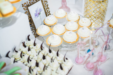Delicious and tasty dessert table with cupcakes and shots at reception closeup