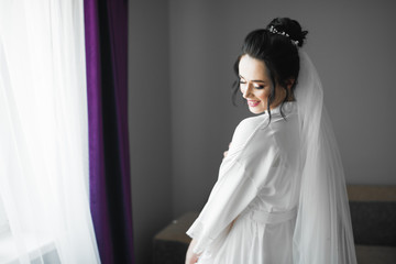 Fototapeta premium Portrait of beautiful bride with fashion veil at wedding morning