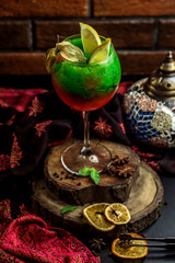 red and green cocktail topped with lemon