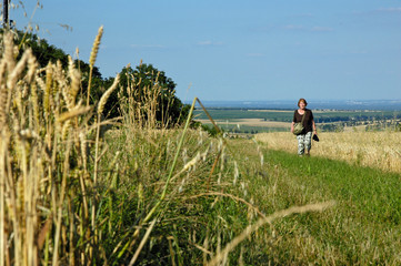 eine frau geht zwischen getreidefeldern