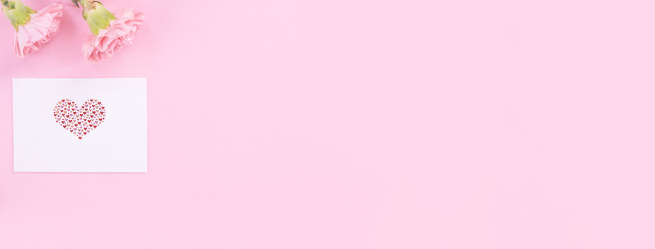 Beautiful, fresh elegant carnation flower bouquet with white greeting thanks gift card isolated on bright pink color background, top view, flat lay concept.