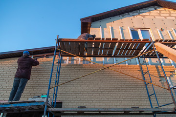 Naklejka premium Installation of siding on the walls of the house