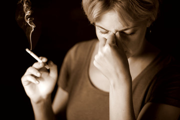 Obraz premium Woman smokes cigarette and has strong headache. Nicotine addiction and health problem concept