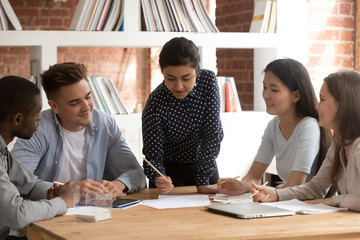 Group of mixed race young people involved in studying process.