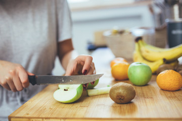 woman cutting fruits with knife. preparing smoothie