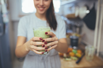 woman holding smoothie in kitchen
