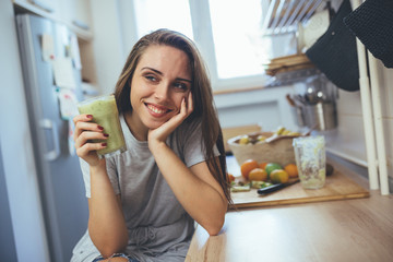 woman drinking smoothie in kitchen