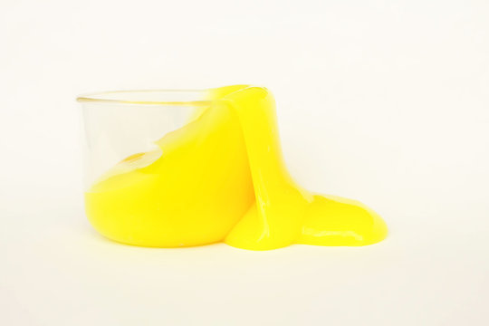 Toy called slime spilling from the jar. Transparent yellow mucus isolated on a white background. Selective focus