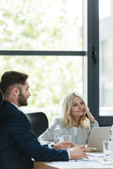 positive, attentive businesswoman listening to young colleague during business meeting