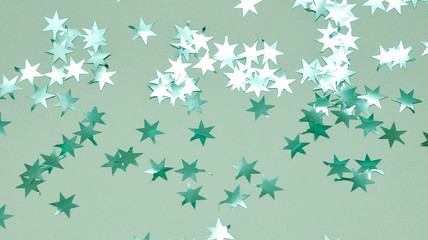 Glitters stars on mint color background.