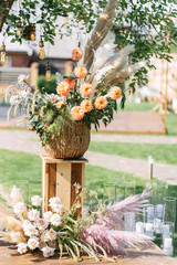 Outdoor wedding ceremony. Composition of chrysanthemums, pampas grass and roses