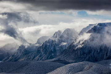 Beautiful mountain panorama in winter with fog and clouds. Bucegi mountains seen from Postavaru, Romania.