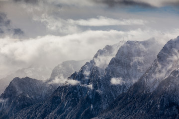 Beautiful mountain panorama in winter with fog and clouds. Bucegi mountains seen from Postavaru, Romania.