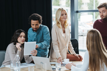 young multicultural businesspeople discussing business ideas during meeting in office