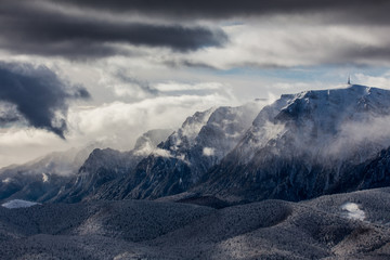 Obraz premium Beautiful mountain panorama in winter with fog and clouds. Bucegi mountains seen from Postavaru, Romania.