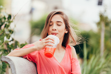 12 years old teenage girl drinking juice outdoors