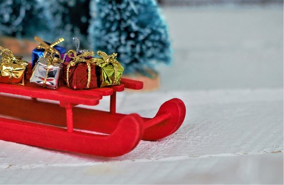 Red miniature sled (sleigh) with gifts and presents on it. Wonderful christmas concept